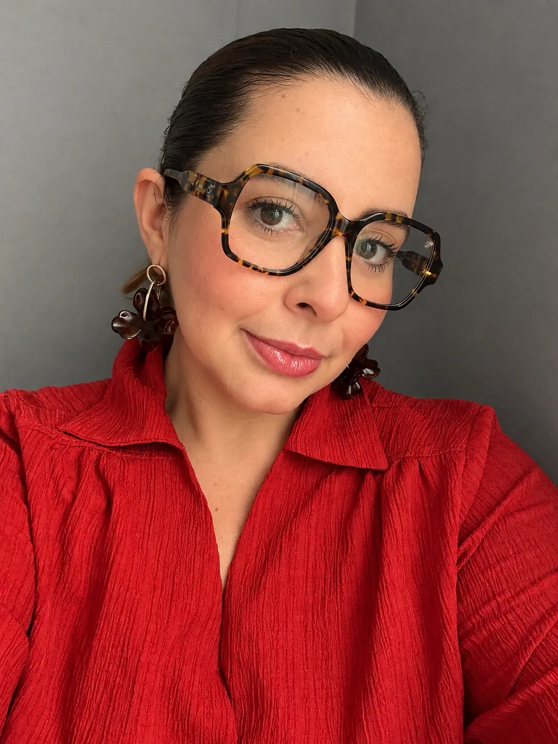 Retrato da psicóloga Juliana Henry, de óculos e camisa vermelha