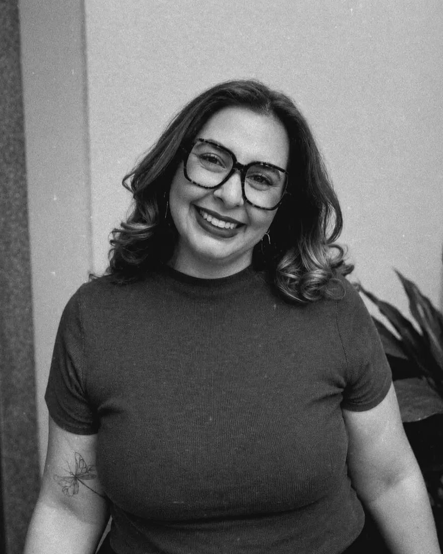Juliana sorrindo, em foto em preto e branco